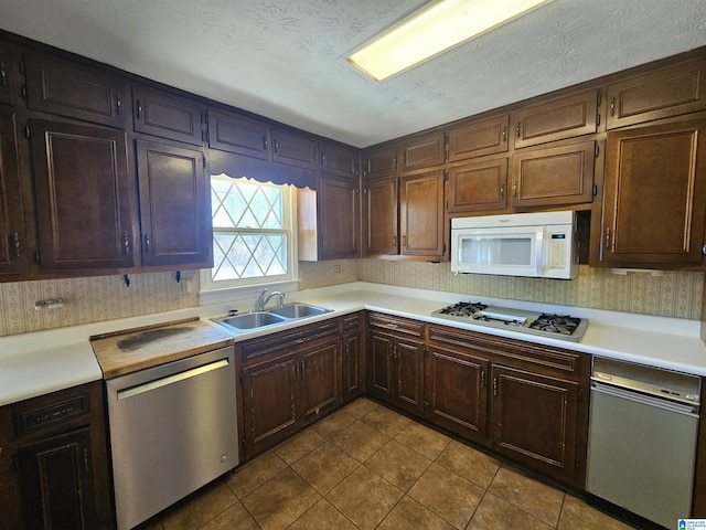 kitchen featuring a sink, white appliances, and light countertops