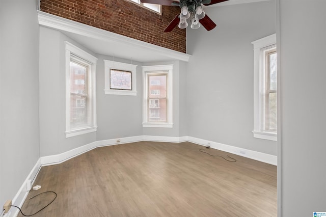 empty room with ceiling fan, baseboards, and wood finished floors