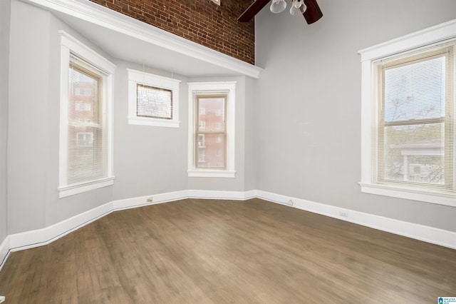 spare room with a ceiling fan, baseboards, and dark wood-style flooring