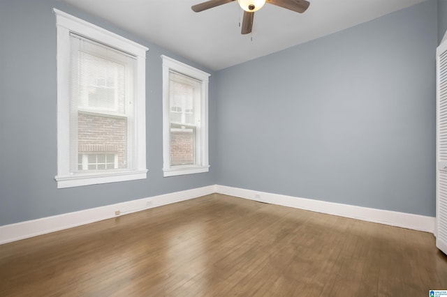 unfurnished room with a ceiling fan, wood finished floors, and baseboards