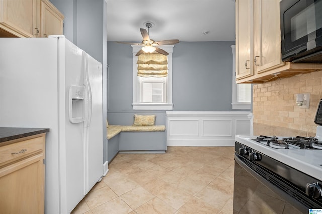 kitchen featuring light brown cabinetry, ceiling fan, white refrigerator with ice dispenser, black microwave, and range with gas cooktop