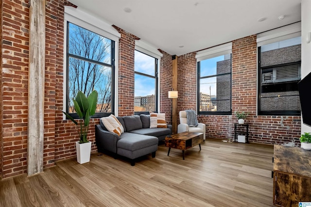 living area featuring wood finished floors and brick wall