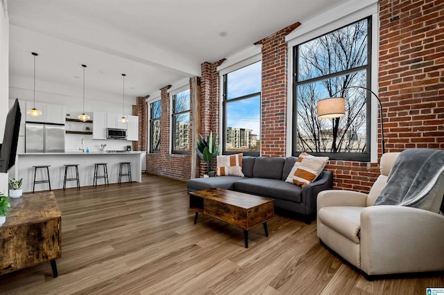 living room with light wood-type flooring and brick wall