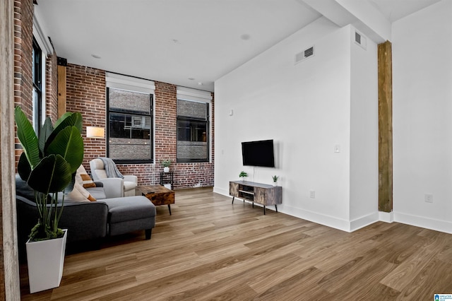 living room with wood finished floors, visible vents, and baseboards