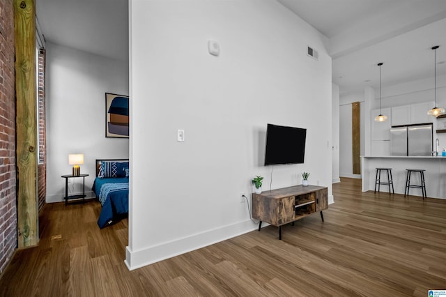 living room featuring wood finished floors, visible vents, and baseboards