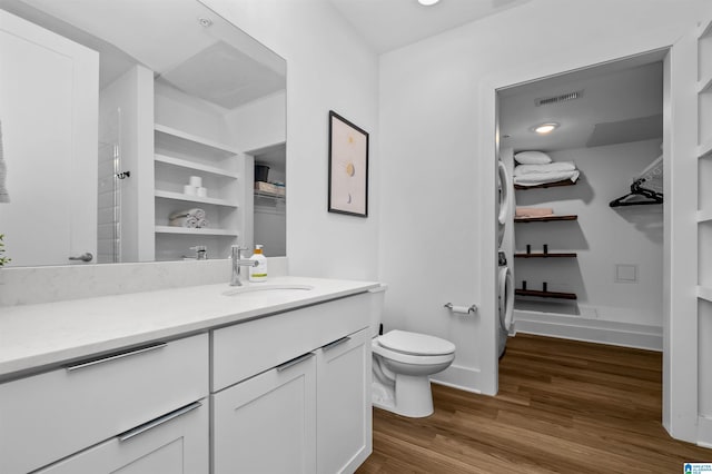 full bathroom with visible vents, baseboards, toilet, wood finished floors, and vanity