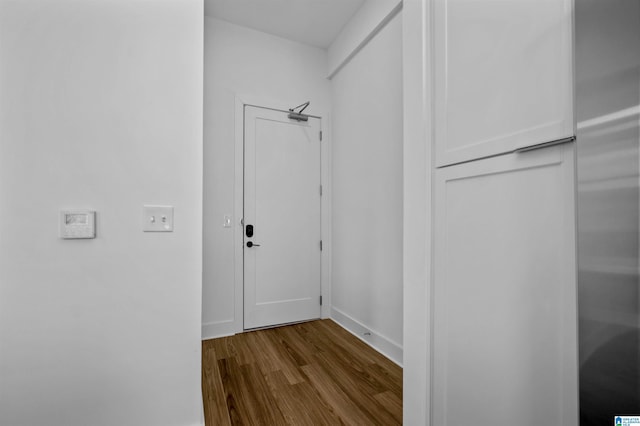 corridor with baseboards and dark wood-type flooring