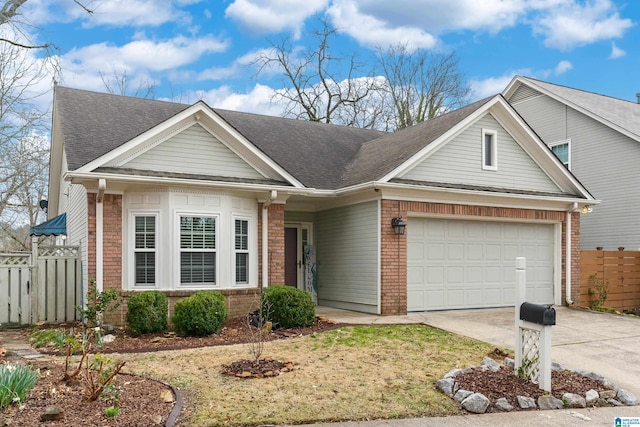 view of front of house with brick siding, an attached garage, concrete driveway, and fence