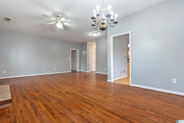 interior space featuring a textured ceiling, ceiling fan with notable chandelier, dark wood-style flooring, and baseboards