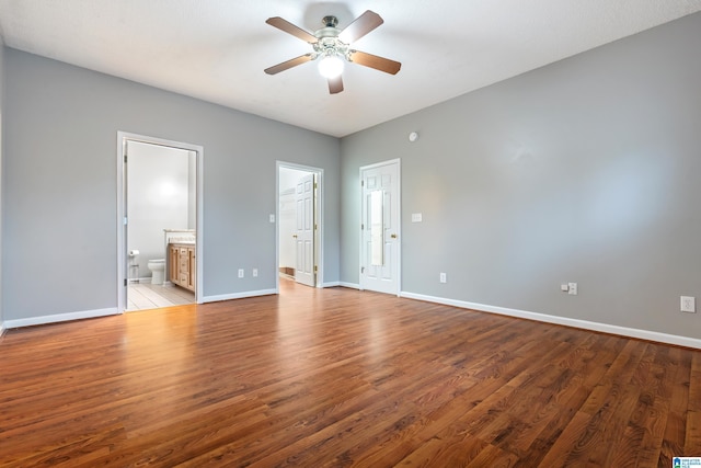 unfurnished bedroom featuring baseboards, ensuite bath, a ceiling fan, and light wood finished floors