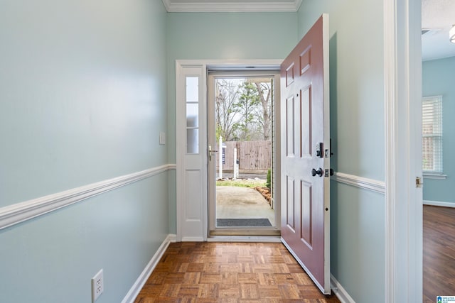 foyer entrance with crown molding and baseboards