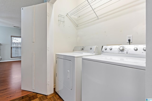 clothes washing area featuring a textured ceiling, independent washer and dryer, and laundry area