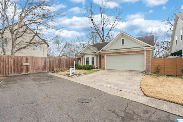 view of front of property featuring concrete driveway, an attached garage, fence, and brick siding