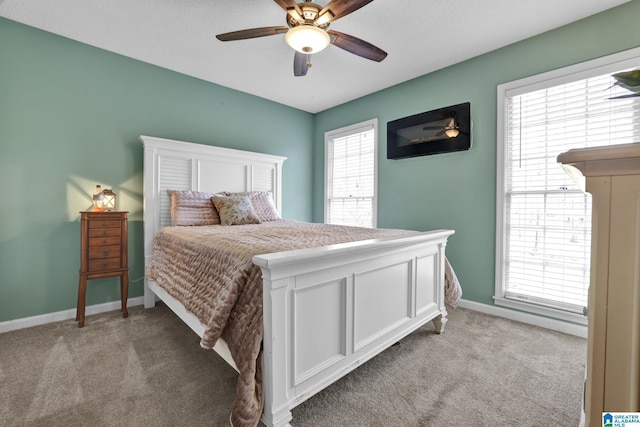 bedroom featuring baseboards, light carpet, and ceiling fan