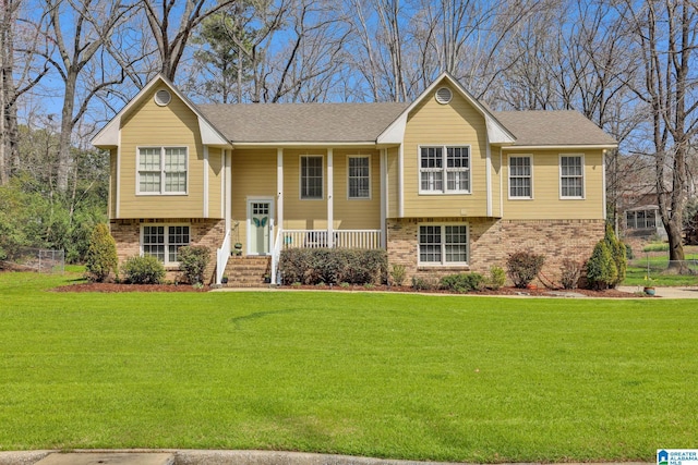 split foyer home with brick siding, a porch, and a front yard