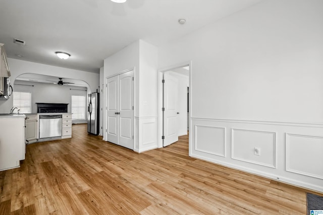 kitchen with a ceiling fan, visible vents, light wood-style flooring, stainless steel appliances, and open floor plan