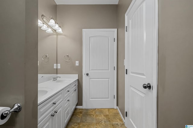 full bathroom featuring a sink, baseboards, double vanity, and stone finish floor