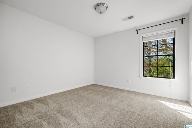 carpeted empty room with visible vents and baseboards