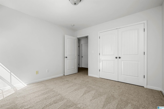 unfurnished bedroom with a closet, baseboards, and carpet flooring