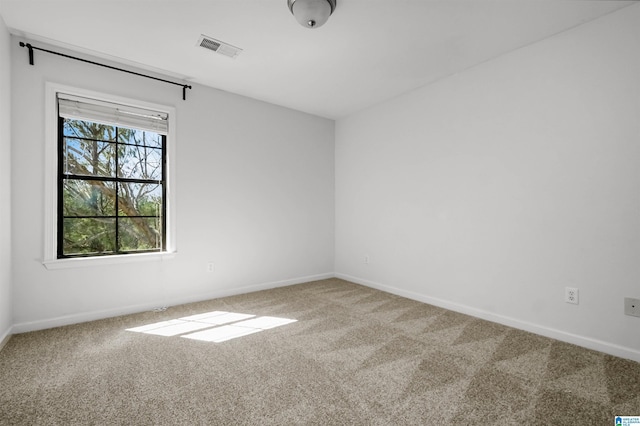 empty room featuring visible vents, baseboards, and carpet