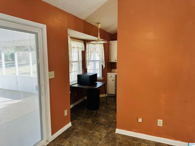 home office with baseboards, a wealth of natural light, and a textured ceiling