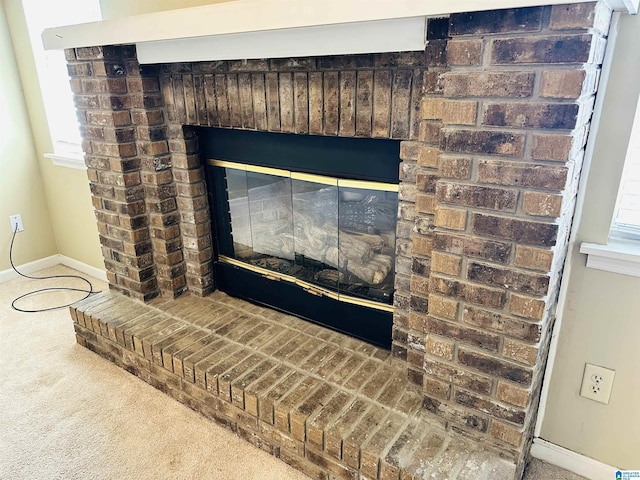 room details featuring baseboards, a brick fireplace, and carpet flooring