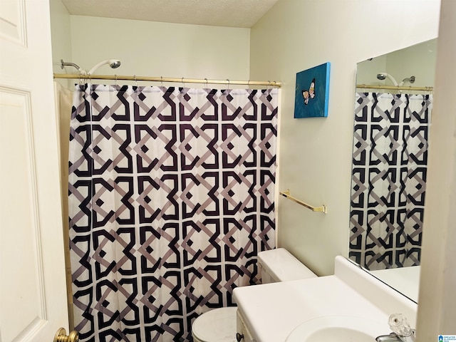 bathroom with a shower with curtain, toilet, vanity, and a textured ceiling