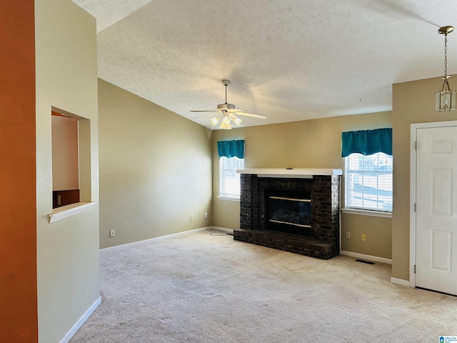 unfurnished living room featuring a brick fireplace, baseboards, carpet floors, and ceiling fan