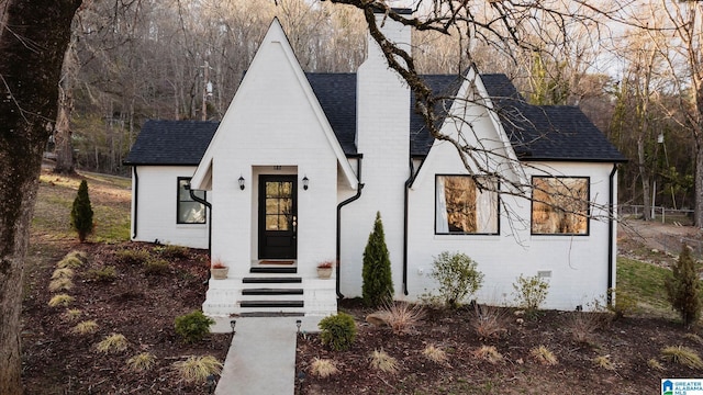 view of front of house featuring brick siding and a shingled roof