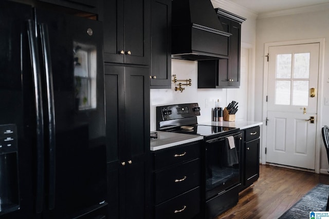 kitchen with black appliances, dark cabinetry, crown molding, and custom range hood