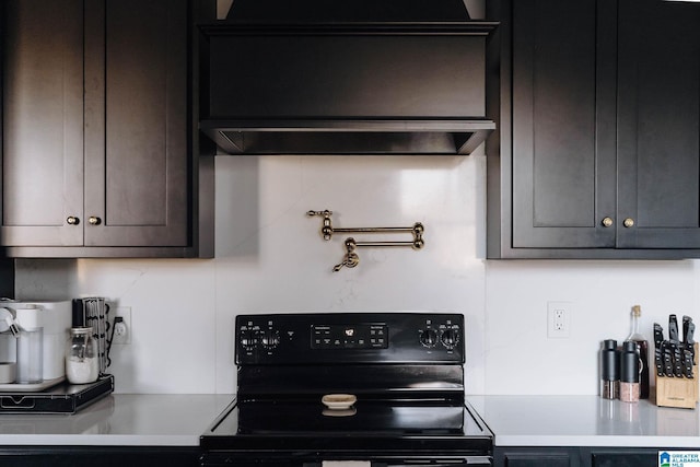 kitchen featuring tasteful backsplash, light countertops, black range with electric cooktop, and extractor fan