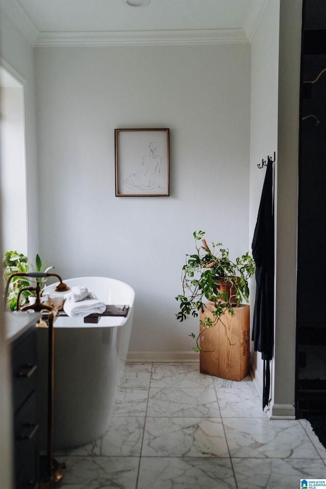 bathroom featuring baseboards, a freestanding bath, marble finish floor, and crown molding