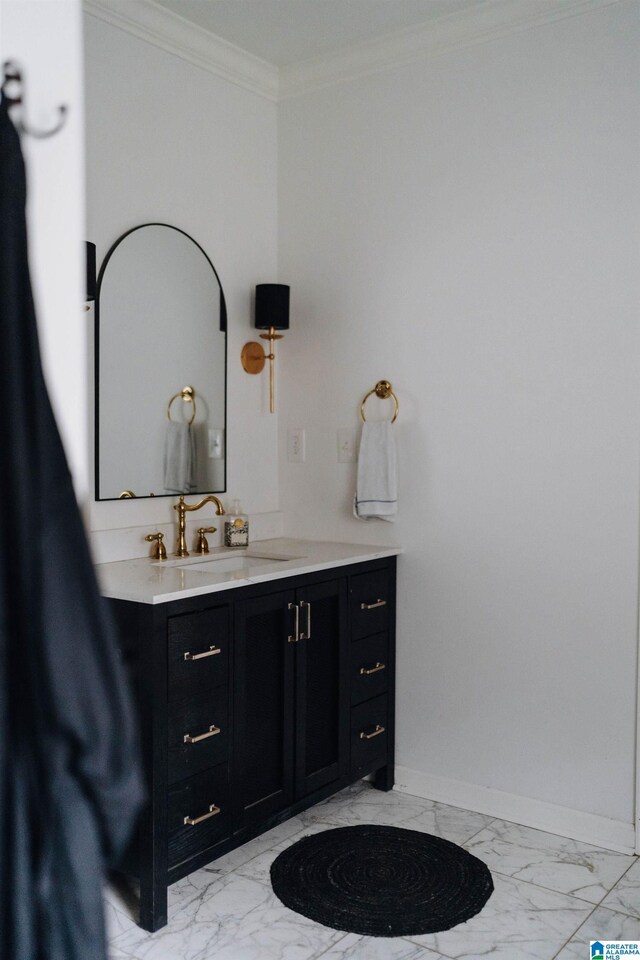 bathroom with marble finish floor, vanity, baseboards, and ornamental molding