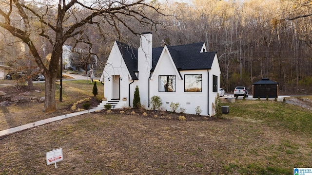 view of front of property with crawl space, a chimney, and a shingled roof