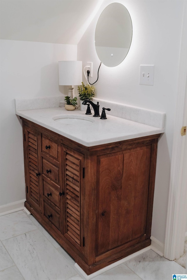 bathroom with vanity, baseboards, and marble finish floor