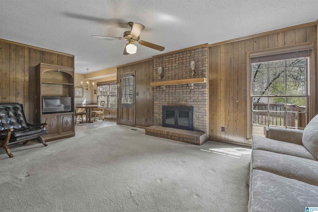 unfurnished living room with wooden walls, ceiling fan with notable chandelier, a textured ceiling, and carpet