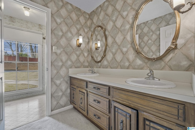 full bath with double vanity, tile patterned floors, tile walls, and a sink