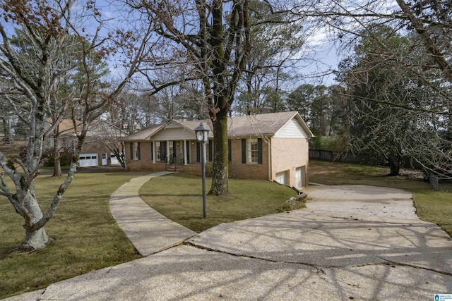 view of front of home featuring a front lawn, an attached garage, brick siding, and driveway