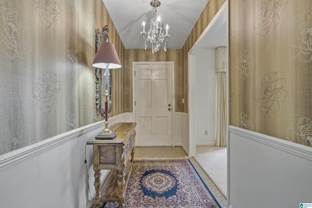 carpeted foyer with lofted ceiling and an inviting chandelier