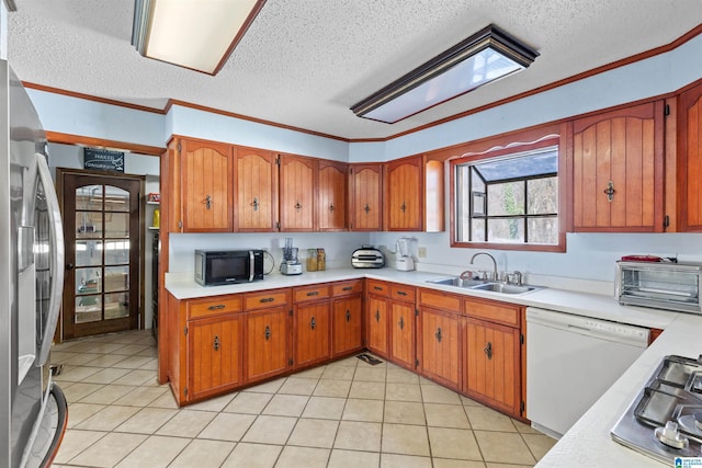 kitchen featuring a sink, brown cabinets, appliances with stainless steel finishes, and light countertops