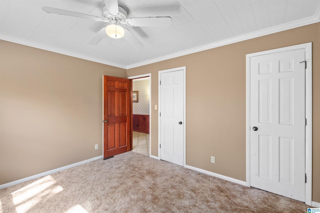 unfurnished bedroom with a ceiling fan, baseboards, carpet floors, and ornamental molding