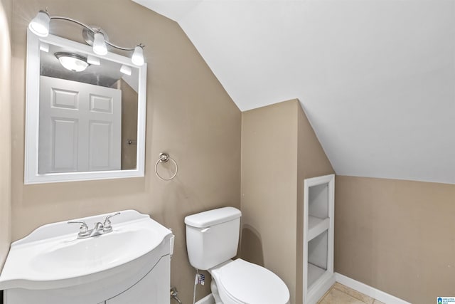 bathroom featuring baseboards, lofted ceiling, toilet, and vanity