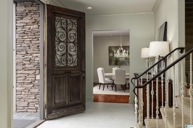 foyer entrance featuring crown molding, stairway, a notable chandelier, and baseboards