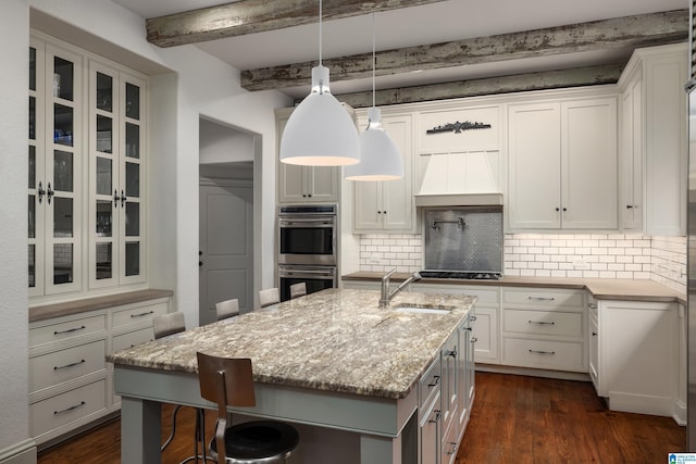 kitchen featuring glass insert cabinets, stainless steel double oven, backsplash, and dark wood-type flooring