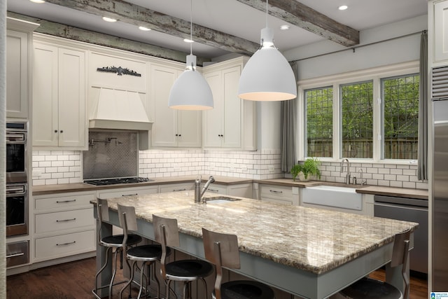 kitchen featuring custom exhaust hood, dark wood-style flooring, white cabinets, and a sink