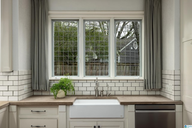 room details with butcher block counters, white cabinets, backsplash, and a sink