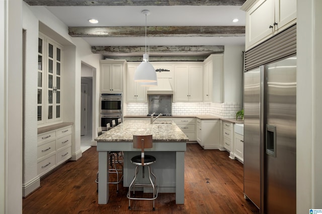 kitchen with stainless steel appliances, dark wood finished floors, and decorative backsplash