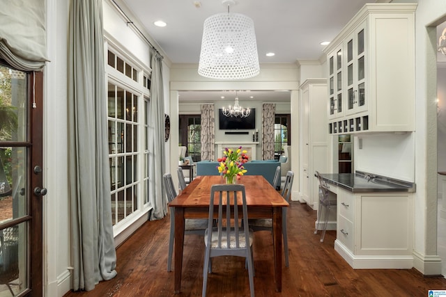 dining room featuring dark wood finished floors, crown molding, recessed lighting, and a chandelier