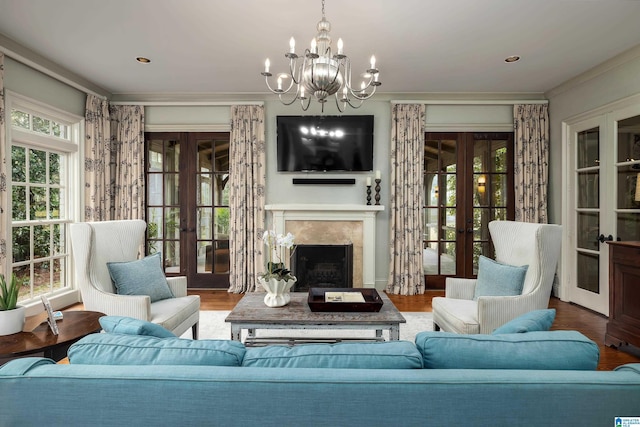 living room with wood finished floors, french doors, a high end fireplace, and a chandelier