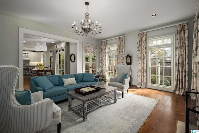 living room featuring ornamental molding, hardwood / wood-style floors, recessed lighting, french doors, and an inviting chandelier